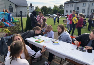 Wolontariuszki SK Caritas malują dzieci uczestniczące w pikniku